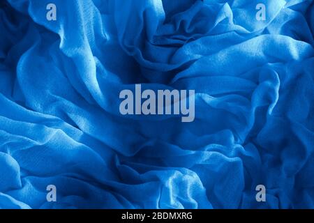 Texture of classic blue Wrinkled Fabric. Trendy color of clothes. Close-up. Stock Photo