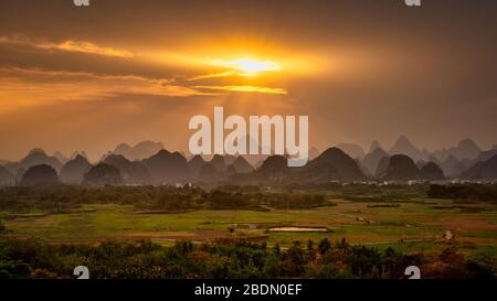 Rays of sun shining through clouds, on top of limestone mountains of Guilin, China. Stock Photo