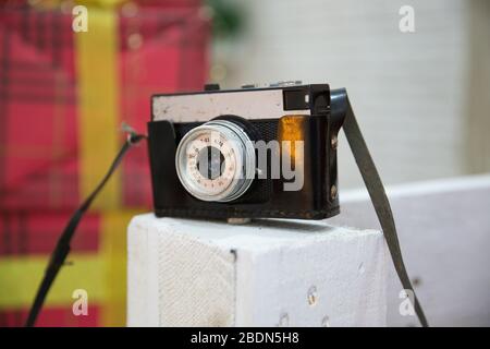 White wooden background close-up. Vintage photo . Retro film photo camera isolated on white wooden background . Old film camera. Stock Photo