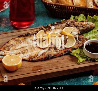 Fried fish with fries and lemon garnish on a restaurant plate Stock ...