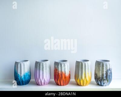 Cactus pot. Concrete pot. Empty colorful concrete planters on white wooden shelf isolated on white background with copy space. Stock Photo