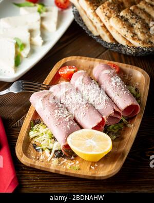 ham wrapped in a roll and sprinkled with grated parmesan Stock Photo