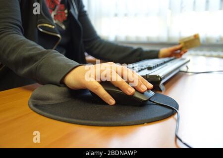 Midsection of woman holding credit card and shopping online Stock Photo