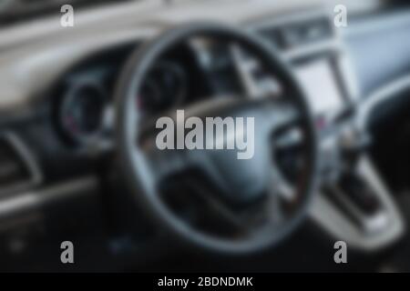 Abstract blur view of the steering wheel of a car. Car dashboard. Modern car interior details. Defocused. Stock Photo