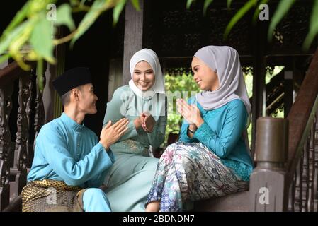 Asian Malay Muslim greetings during Hari Raya Aidilfitri. Malaysian people living lifestyle. Stock Photo