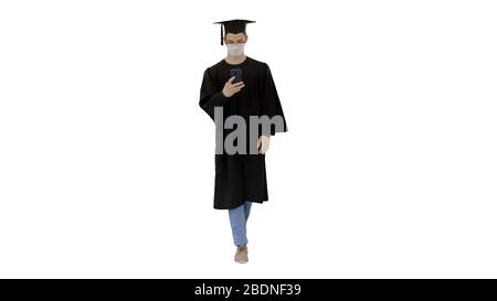 Young man with graduation gown walking in medical mask using sma Stock Photo