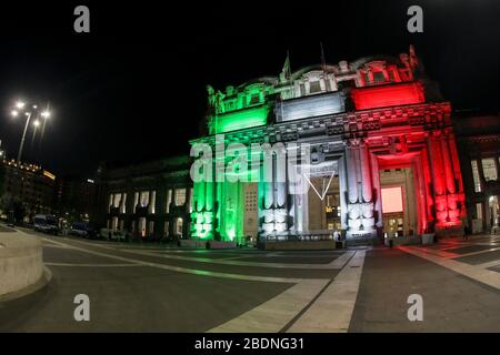 The facade of Milan Central Station illuminated with the Italian flag, Milan, April 2020. For the first time in 90 years of history, Milan Central Station is illuminated with the Italian flag - the Tricolore - by Gruppo Ferrovie dello Stato Italiano and Milano Centrale to pay homage to the city from one of its iconic locations. Stock Photo