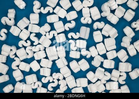 Foam cushion or corn cushion E shape, packaging material shockproof for fragile parcel isolated on blue background Stock Photo