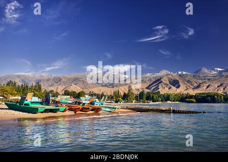 Colorful Old school boats and catamarans on the beach of Issyk Kul Lake in Kyrgyzstan Stock Photo