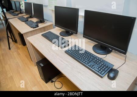 two computers and a desk . Keyboard and mouse . Two computer monitors with a black screen on a desk . Stock Photo