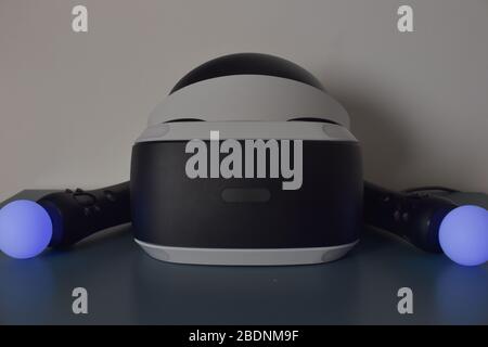 front of psvr with a blue move controller on each side on blue table and white wall in the background Stock Photo