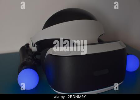 psvr with a blue move controller on each side on blue table and white wall in the background Stock Photo