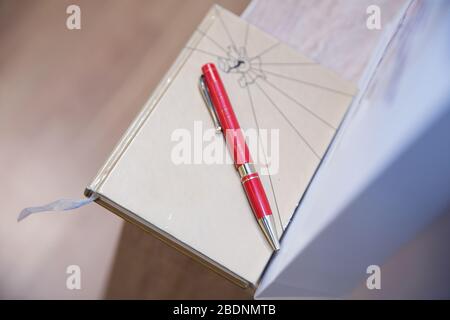 notebook with red pencil on wooden table . Brown notebook and red pencil on the table. Stock Photo