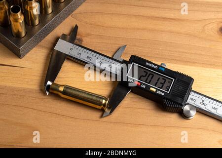 Production of cartridges for a rifle, reload. Measurement of the empty cartridges with a caliper. Top view Stock Photo