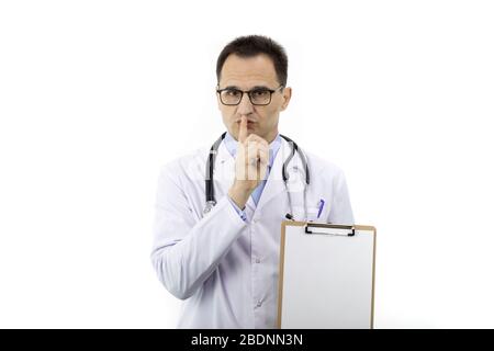 Doctor with blank clipboard making silence gesture. Medical confidentiality Stock Photo