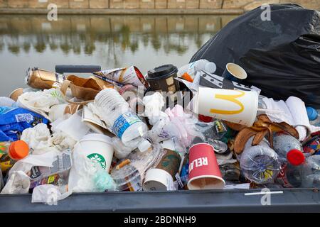 PARIS - NOVEMBER 8, 2019: Full garbage bin with colorful rubbish in Paris Stock Photo