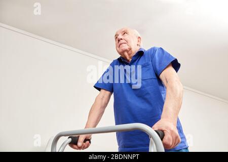 Old man walking with walking aid in rehab or physiotherapy Stock Photo