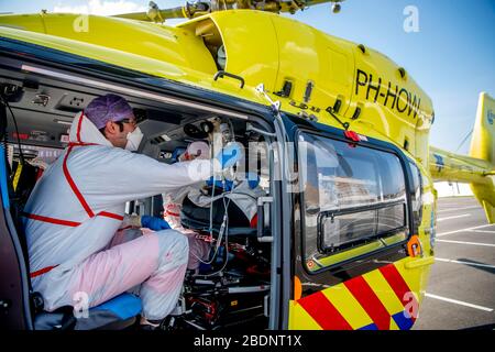 A medical worker on board the Lifeliner 5 ambulance helicopter as it prepares to depart for Germany carrying a COVID-19 coronavirus patient.Due to the large amount of patients infected with the COVID-19 coronavirus, the intensive care unit beds are in shortage in the Netherlands. Germany has agreed to help by accepting patients to receive treatments in hospitals in Germany. The Lifeliner 5 ambulance helicopter has been assigned to transport CCOVID-19 patients to German hospitals from the Netherlands. There are currently more than 20,000 confirmed cases of COVID-19 which has already caused over Stock Photo