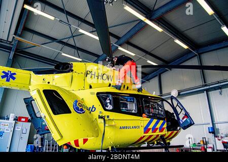 A helicopter crew of the Lifeliner 5 ambulance helicopter prepares the aircraft for a journey to transport a COVID-19 patient to Germany.Due to the large amount of patients infected with the COVID-19 coronavirus, the intensive care unit beds are in shortage in the Netherlands. Germany has agreed to help by accepting patients to receive treatments in hospitals in Germany. The Lifeliner 5 ambulance helicopter has been assigned to transport CCOVID-19 patients to German hospitals from the Netherlands. There are currently more than 20,000 confirmed cases of COVID-19 which has already caused over 2, Stock Photo