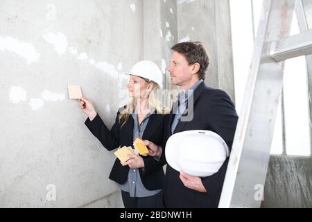 man and woman architects or interior designer work together with color samples choose the color of the wall in the inside the construction building si Stock Photo