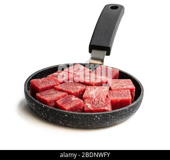 Cubes  of raw beef meat on small frying pan isolated on white Stock Photo