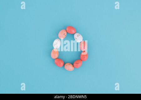 The egg made of small colour eggs on the blue blackground. Easter concept. Stock Photo