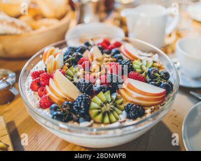Delicious homemade cereal bowl / bircher muesli with fresh fruits on breakfast table Stock Photo