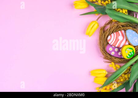 Easter cookies and yellow tulips on a pink background Stock Photo