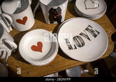 London, UK - 15 January 2020 White porcelain mugs and saucers with a red heart print and sign Love Stock Photo