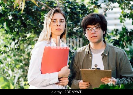 Young agricultural engineers working in greenhouse Stock Photo