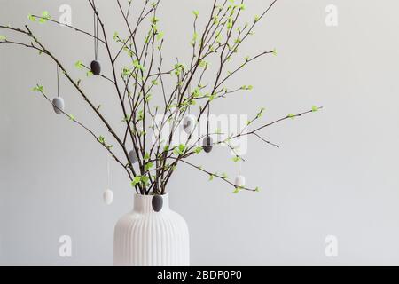 Birch tree branches decorated with white and gray painted eggs. Easter tree. Postcard with a copy space Stock Photo