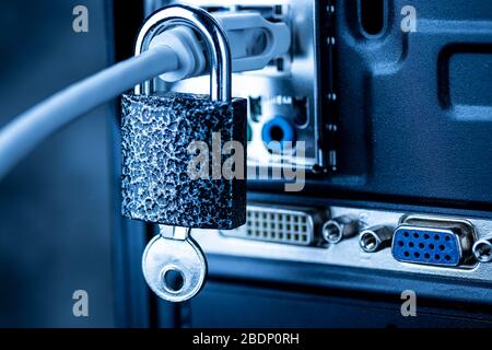 Closed lock with key hanging on a network cable plugged into a computer. The concept of security or blocking the Internet or the safety of personal da Stock Photo