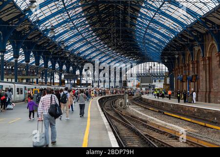 Travellers disembark at Brighton Railway station. Located on the English Channel, Brighton is popular with those looking for a day trip to the beach. Stock Photo