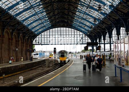 Travellers disembark at Brighton Railway station. Located on the English Channel, Brighton is popular with those looking for a day trip to the beach. Stock Photo