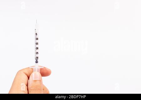 Hand holding an insulin syringe before being used Stock Photo