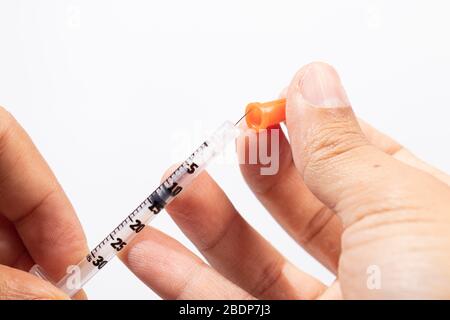 Hand holding an insulin syringe before being used Stock Photo