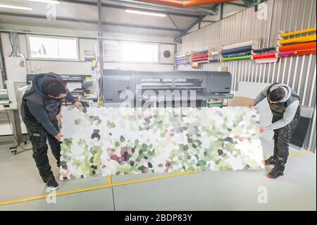 Printmaker Working Two worker printmaker technician operator works in large digital ...