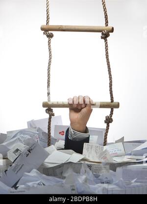 A business concept image of a rope ladder coming out of a pile of receipts with a hand pulling itself out of trouble due to Covid-19 crisis. Stock Photo