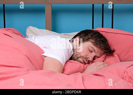 Young caucasian man sleeping in bed. studio shot Stock Photo