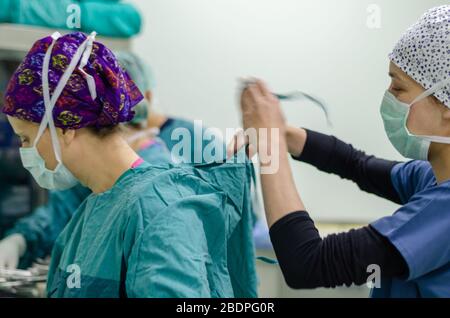 The nurse or doctor is wearing sterile surgical gown preoperative. Stock Photo