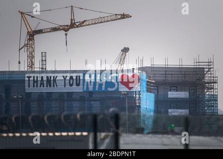 A large banner thanking the NHS on a construction site opposite the ExCel centre in London, a temporary hospital with 4000 beds which has been set up for the treatment of Covid-19 patients. Stock Photo