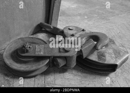 A large metal hook and a roller lying on an old floor near the door Stock Photo