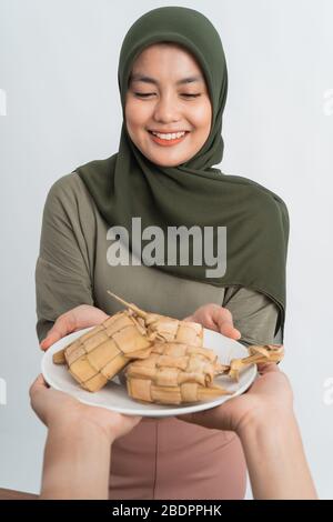muslim woman giving some rice cake on ramadan eid mubarak Stock Photo