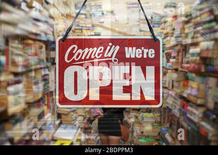 A business sign that says 'Come in We're Open' on a book store window. Stock Photo