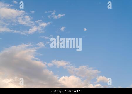 Similar soul, fluffy white clouds in blue sky Background and small full moon. Stock Photo