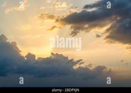Dramatic black and red clouds with sunbeam at sunset Stock Photo