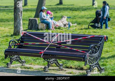 London, UK. 09th Apr, 2020. The benches may be taped off, but there is always somewhere else to sit - Clapham Common is pretty quiet now Lambeth Council has taped up all the benches. The 'lockdown' continues for the Coronavirus (Covid 19) outbreak in London. Credit: Guy Bell/Alamy Live News Stock Photo