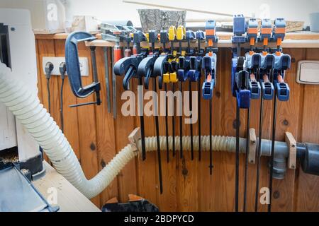 Set of woodworking tools and equipment hanged on wall at carpentry. Different chisels, drills and pencils at craftsman workshop. DIY instruments on Stock Photo