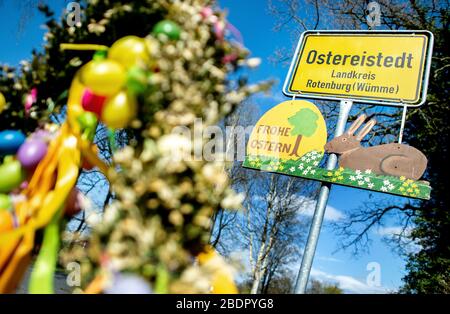 Ostereistedt, Germany. 09th Apr, 2020. A sign with the inscription "Happy Easter" hangs below the place-name sign at the entrance to Ostereistedt. A record number of about 59,000 letters arrived at the Easter Post Office in Ostereistedt this year. The letters will be answered by volunteers until next week. Credit: Hauke-Christian Dittrich/dpa/17�Թ����� Live News Stock Photo