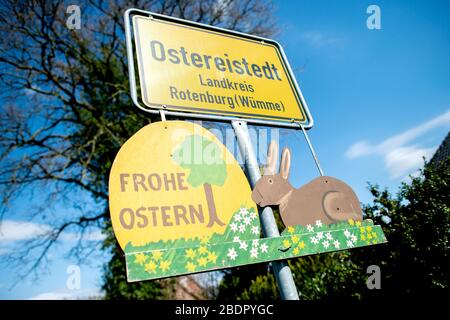 Ostereistedt, Germany. 09th Apr, 2020. A sign with the inscription "Happy Easter" hangs below the place-name sign at the entrance to Ostereistedt. A record number of about 59,000 letters arrived at the Easter Post Office in Ostereistedt this year. The letters will be answered by volunteers until next week. Credit: Hauke-Christian Dittrich/dpa/17�Թ����� Live News Stock Photo